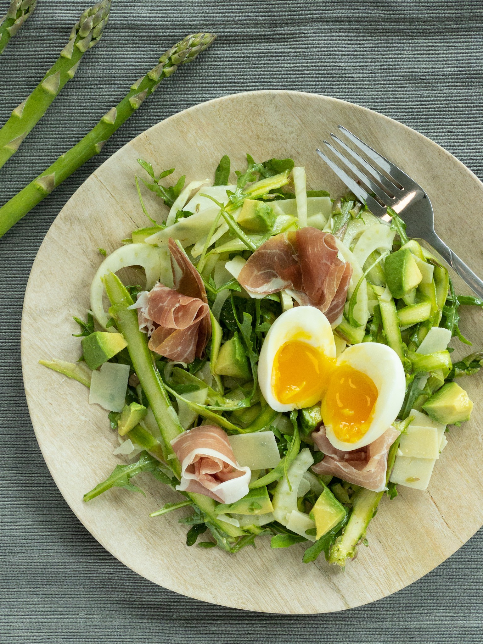 shaved asparagus salad topped with prosciutto and eggs