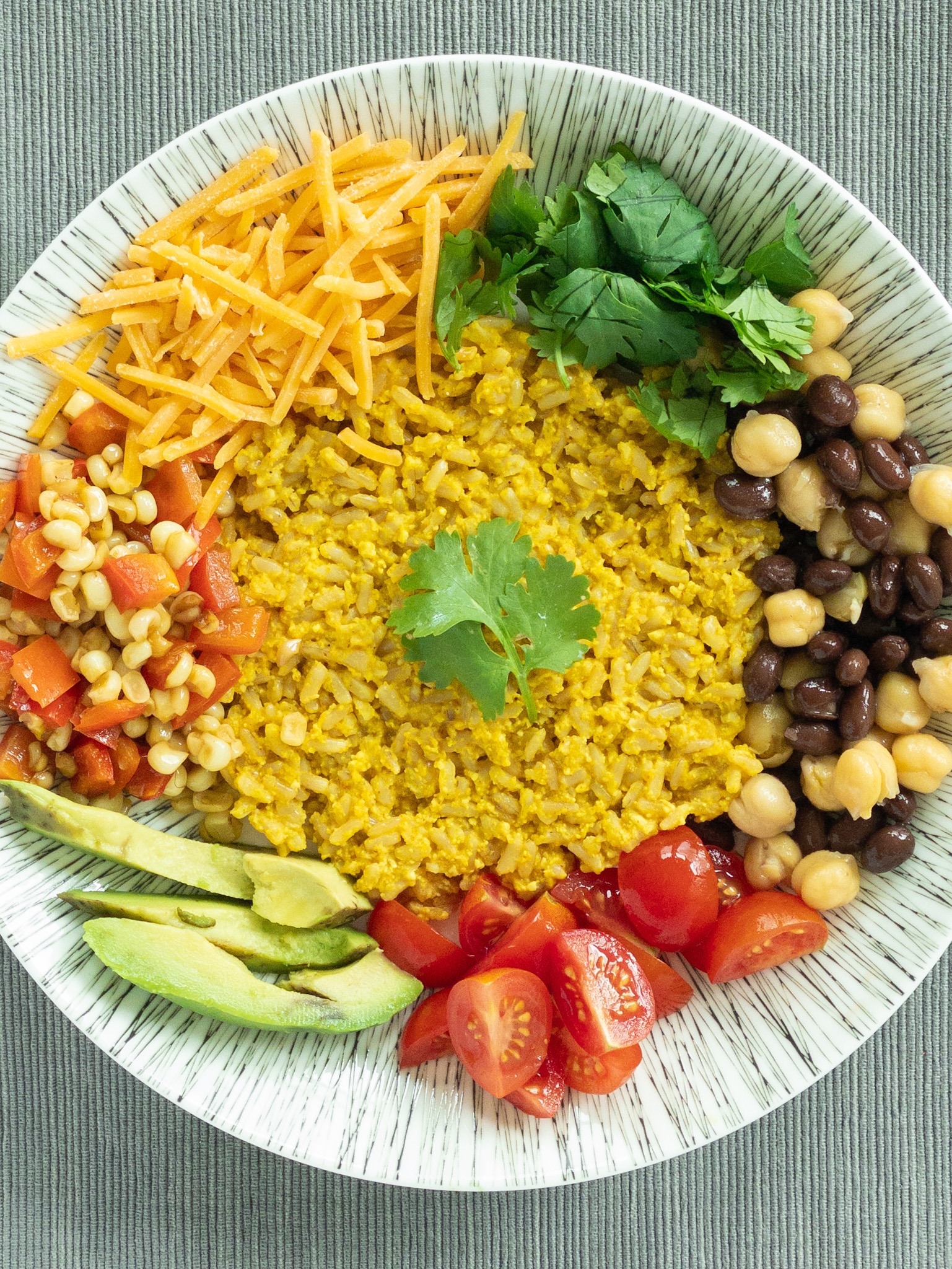 bowl of rice, beans and vegetables with a spicy garlic sauce